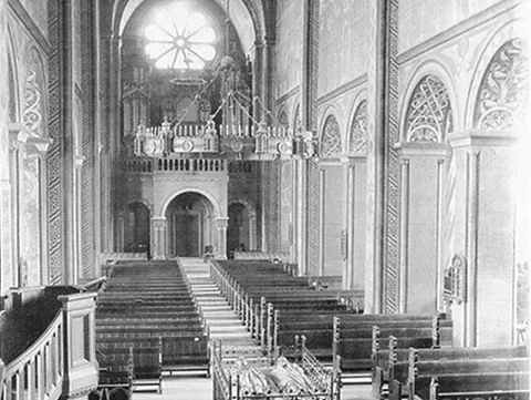 Ein Blick in das Innere einer Kirche mit Kirchenbänken, Gewölben und Fenstern.